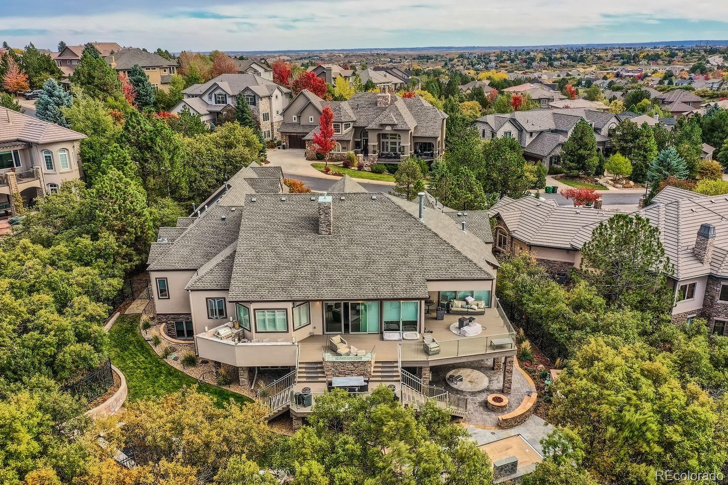 1050 Buffalo Ridge Road Castle Pines, CO 80108 - Photo 50 of 50 an aerial view of a house with swimming pool and large trees