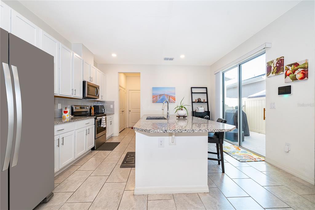 5849 Soter Lane Windermere, FL 34786 - Photo 11 of 31 a kitchen with stainless steel appliances granite countertop a refrigerator and a stove top oven
