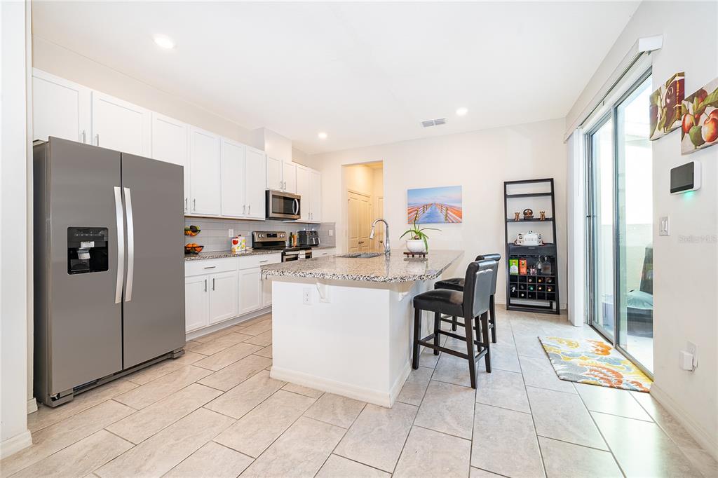 5849 Soter Lane Windermere, FL 34786 - Photo 12 of 31 a kitchen with stainless steel appliances a refrigerator sink and cabinets
