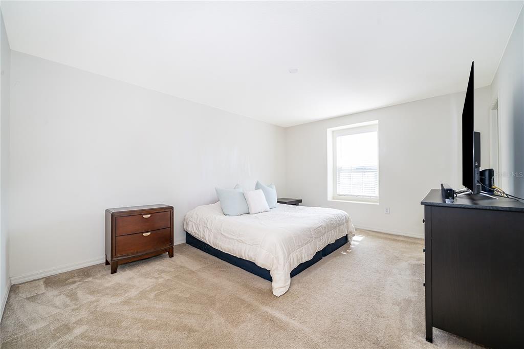 5849 Soter Lane Windermere, FL 34786 - Photo 14 of 31 a bedroom with a bed and a flat tv screen on a dresser