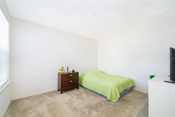 a bedroom with a bed and a potted plant