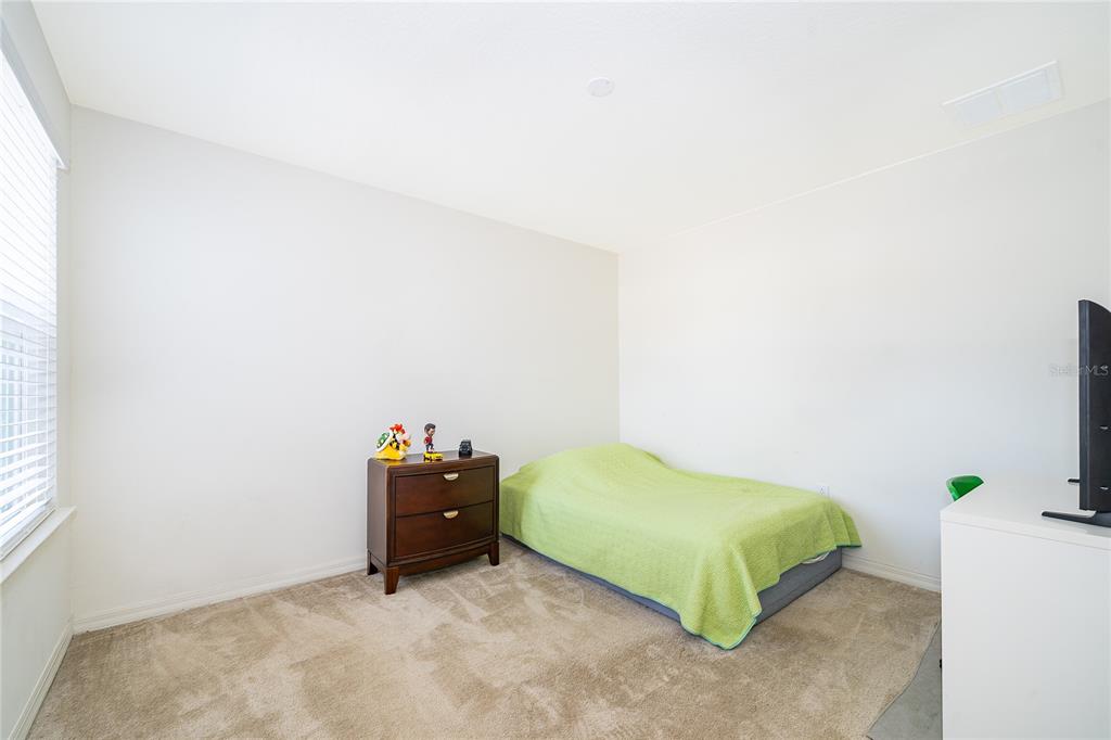 5849 Soter Lane Windermere, FL 34786 - Photo 16 of 31 a bedroom with a bed and a potted plant