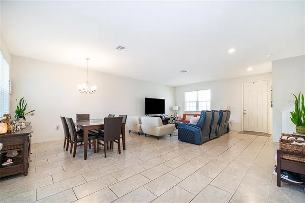 a living room with furniture a dining table and a potted plant