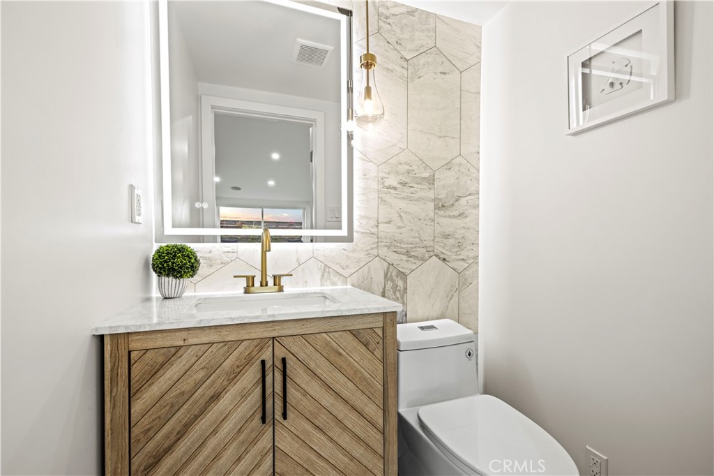 22263 Flanco Road Woodland Hills, CA 91364 - Photo 11 of 69 a bathroom with a sink a toilet and mirror