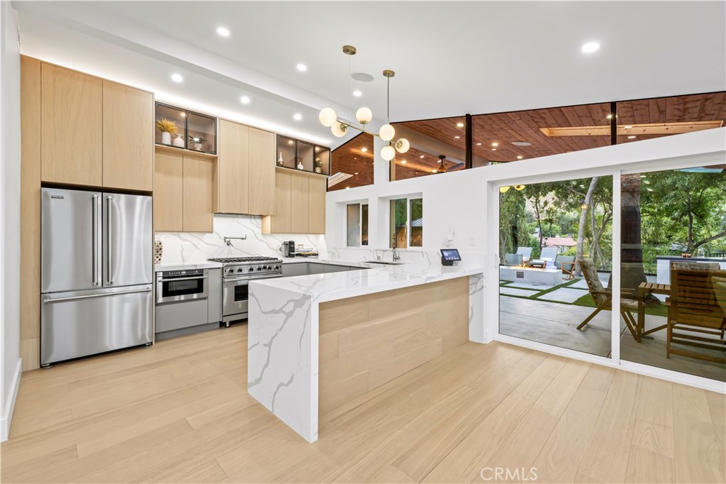 22263 Flanco Road Woodland Hills, CA 91364 - Photo 17 of 69 a large kitchen with stainless steel appliances kitchen island granite countertop a refrigerator and a stove top oven