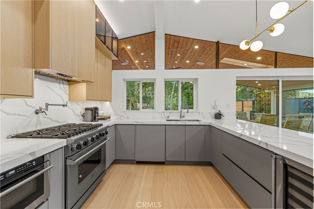 22263 Flanco Road Woodland Hills, CA 91364 - Photo 21 of 69 a kitchen with a sink stove top oven and cabinets
