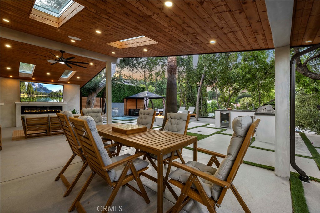 22263 Flanco Road Woodland Hills, CA 91364 - Photo 31 of 69 a view of a patio with a table and chairs under a large umbrella