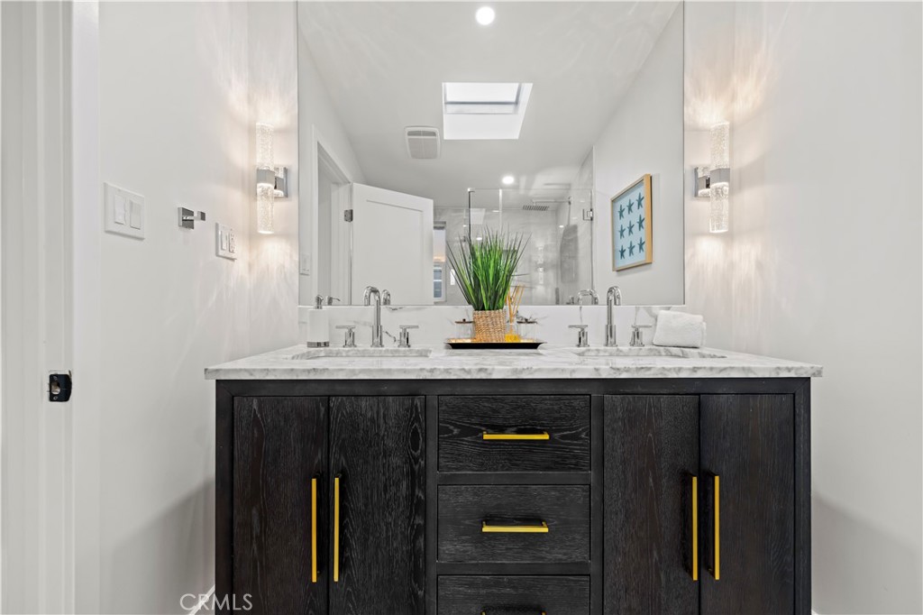 22263 Flanco Road Woodland Hills, CA 91364 - Photo 7 of 69 a bathroom with a granite countertop sink a mirror and shower