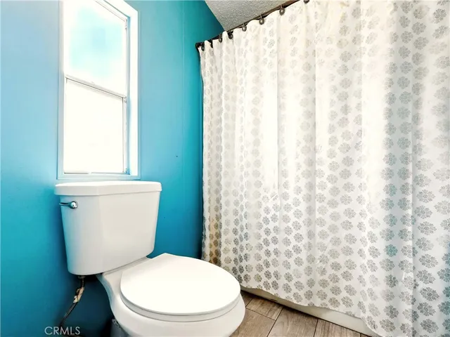 a white toilet sitting next to a shower curtain