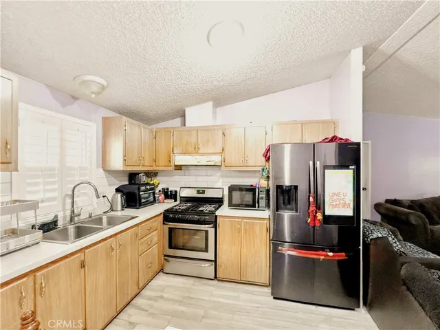 a kitchen with stainless steel appliances a refrigerator sink and cabinets