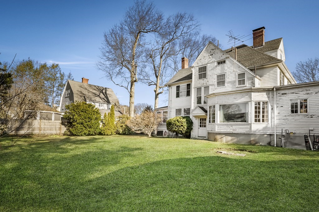 97 Beach Bluff Avenue Swampscott, MA 01907 - Photo 6 of 36 a view of a white house with a big yard and potted plants
