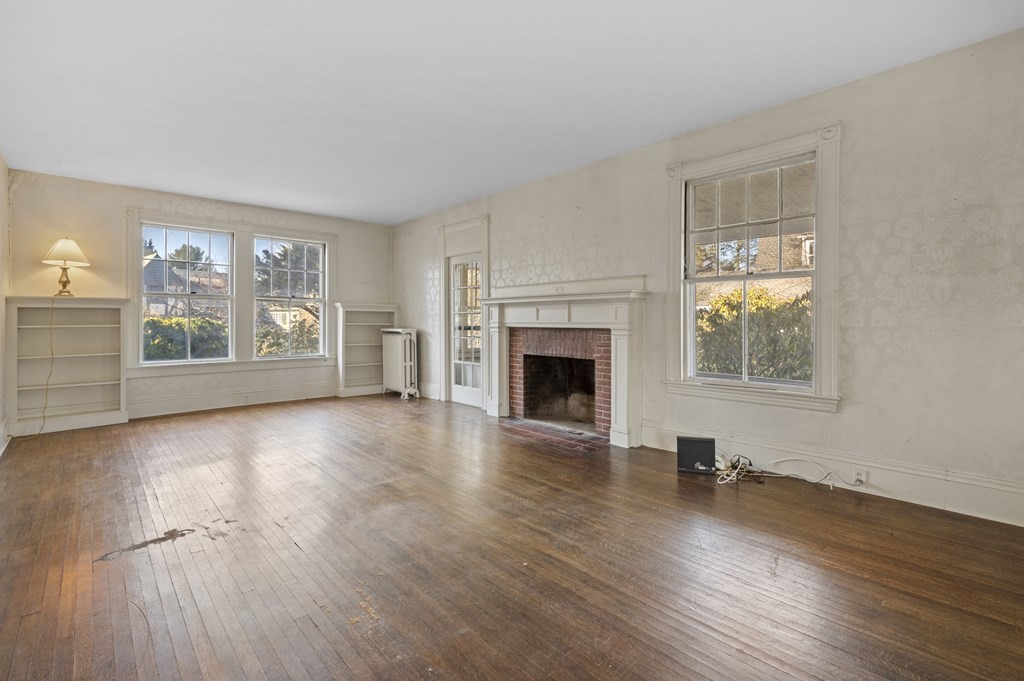 97 Beach Bluff Avenue Swampscott, MA 01907 - Photo 10 of 36 a view of empty room with wooden floor and fireplace