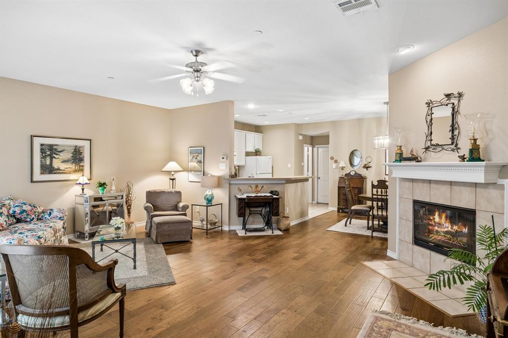 2003 Downing Street Allen, TX 75013 - Photo 8 of 40 The open living area featuring rich Engineered Hardwood Flooring, soft neutral tones, and a stylish gas fireplace with electric starter!