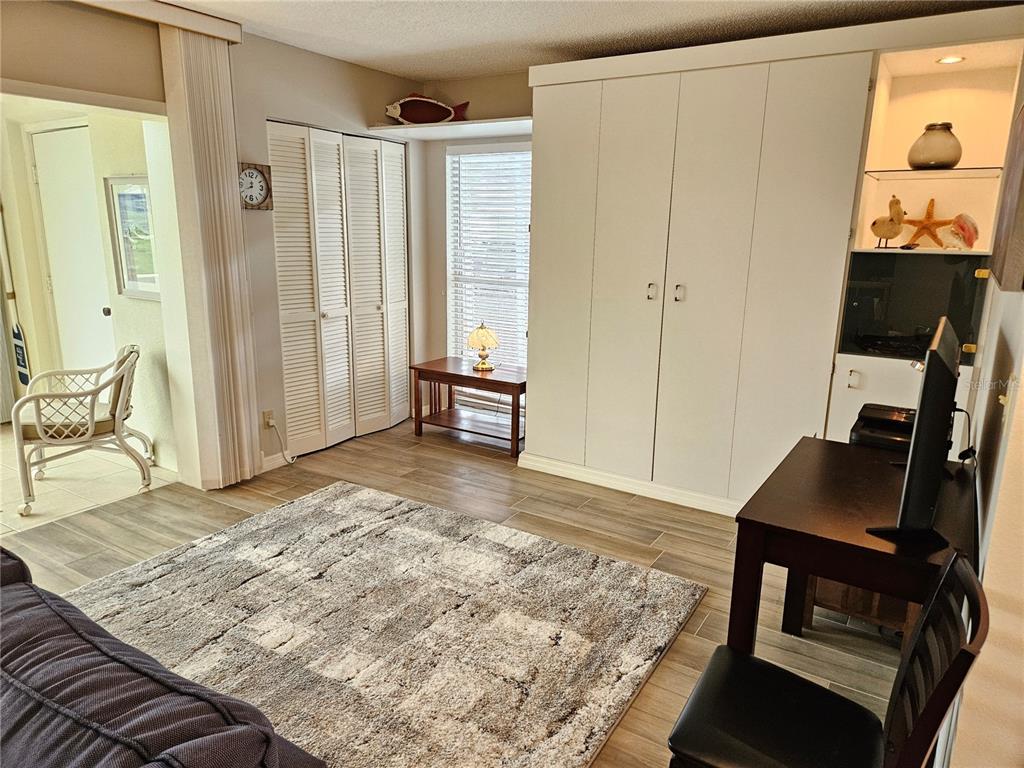 435 Cerromar Lane, Unit 329 Venice, FL 34293 - Photo 18 of 59 a view of a workspace room with wooden floor and bedroom