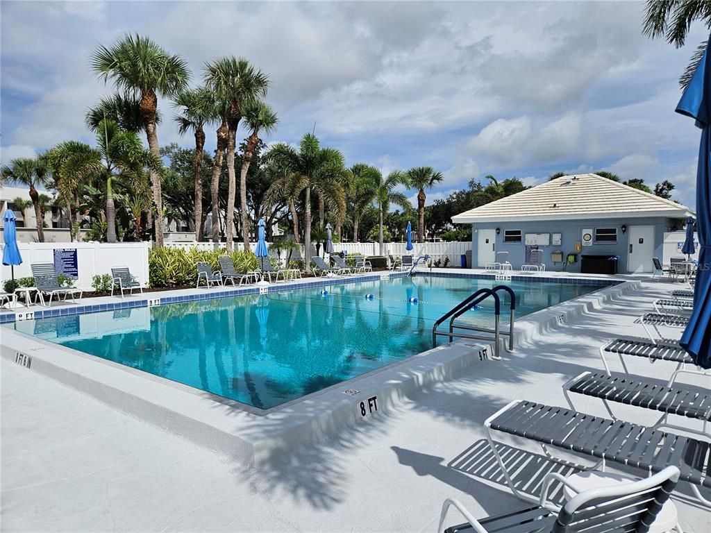 435 Cerromar Lane, Unit 329 Venice, FL 34293 - Photo 3 of 59 a view of a patio with chairs and a table and chairs under an umbrella