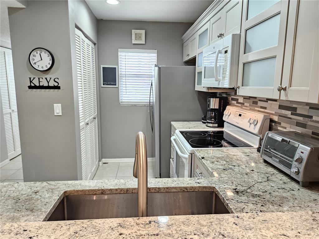 435 Cerromar Lane, Unit 329 Venice, FL 34293 - Photo 38 of 59 a kitchen with stainless steel appliances granite countertop a sink stove and refrigerator