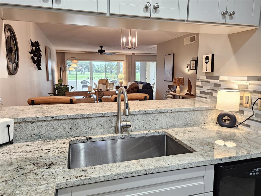 435 Cerromar Lane, Unit 329 Venice, FL 34293 - Photo 39 of 59 a view of a kitchen counter top a sink and dishwasher a fireplace with wooden floor
