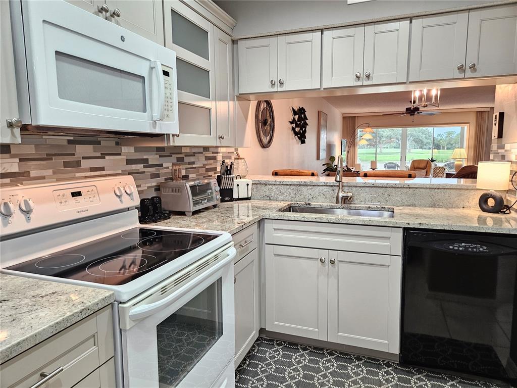 435 Cerromar Lane, Unit 329 Venice, FL 34293 - Photo 40 of 59 a kitchen with a sink stove and cabinets