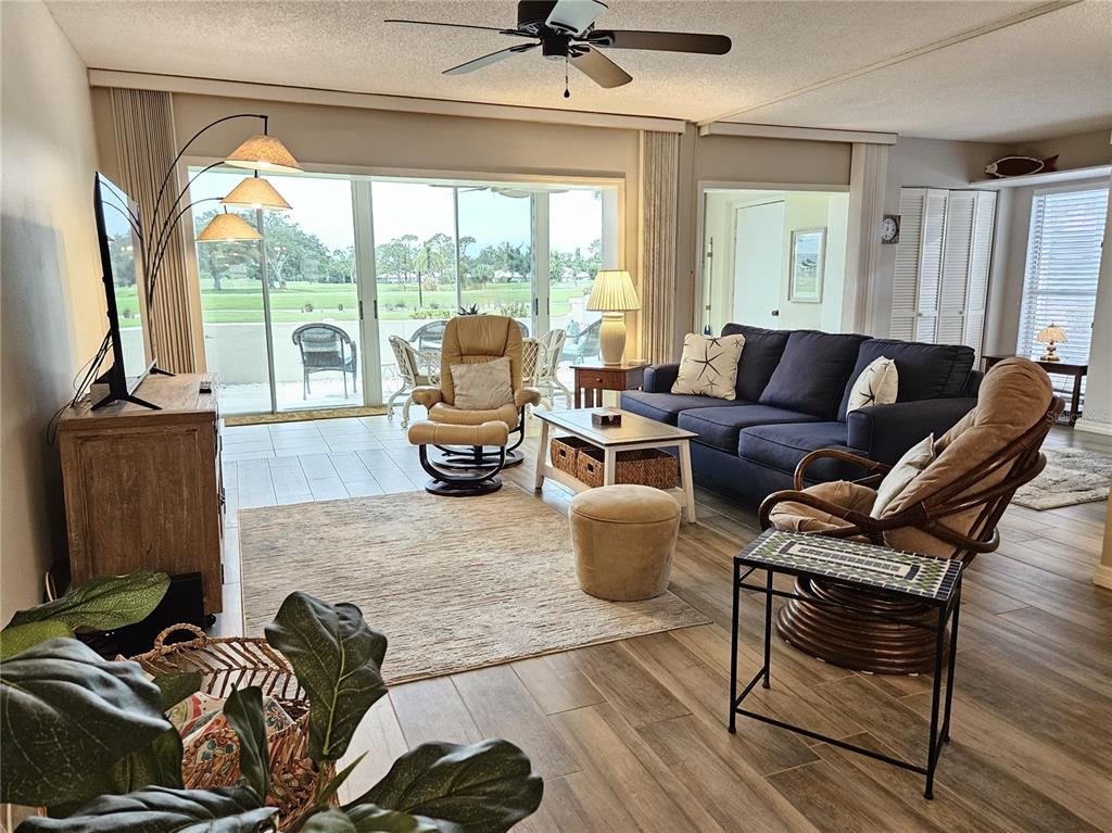 435 Cerromar Lane, Unit 329 Venice, FL 34293 - Photo 8 of 59 a living room with furniture and a floor to ceiling window