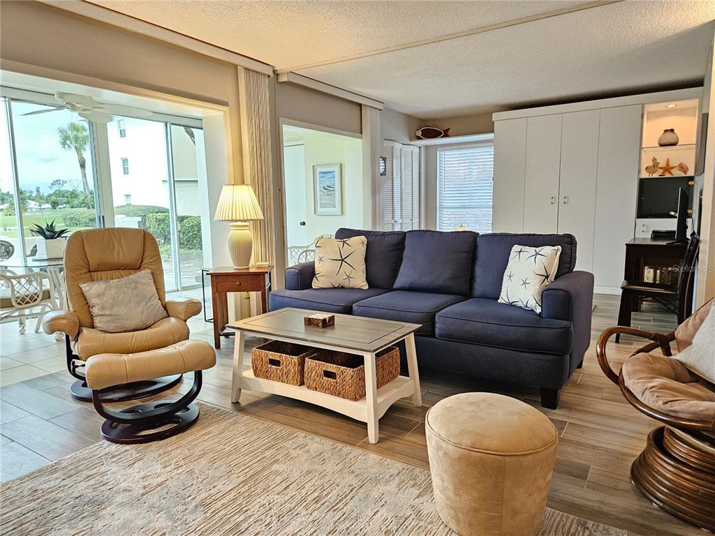 435 Cerromar Lane, Unit 329 Venice, FL 34293 - Photo 9 of 59 a living room with furniture and a floor to ceiling window