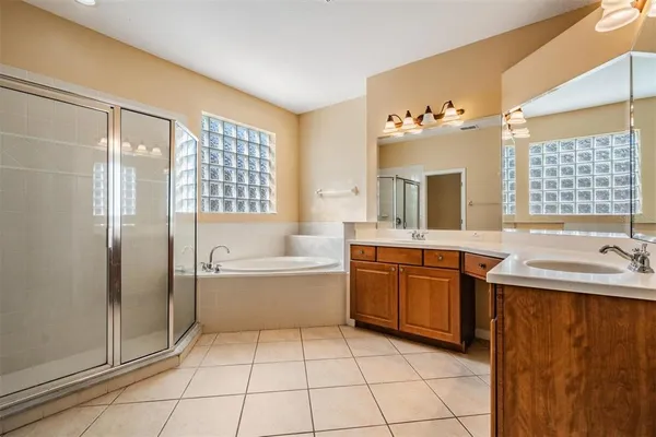 a spacious bathroom with a double vanity sink mirror and bathtub