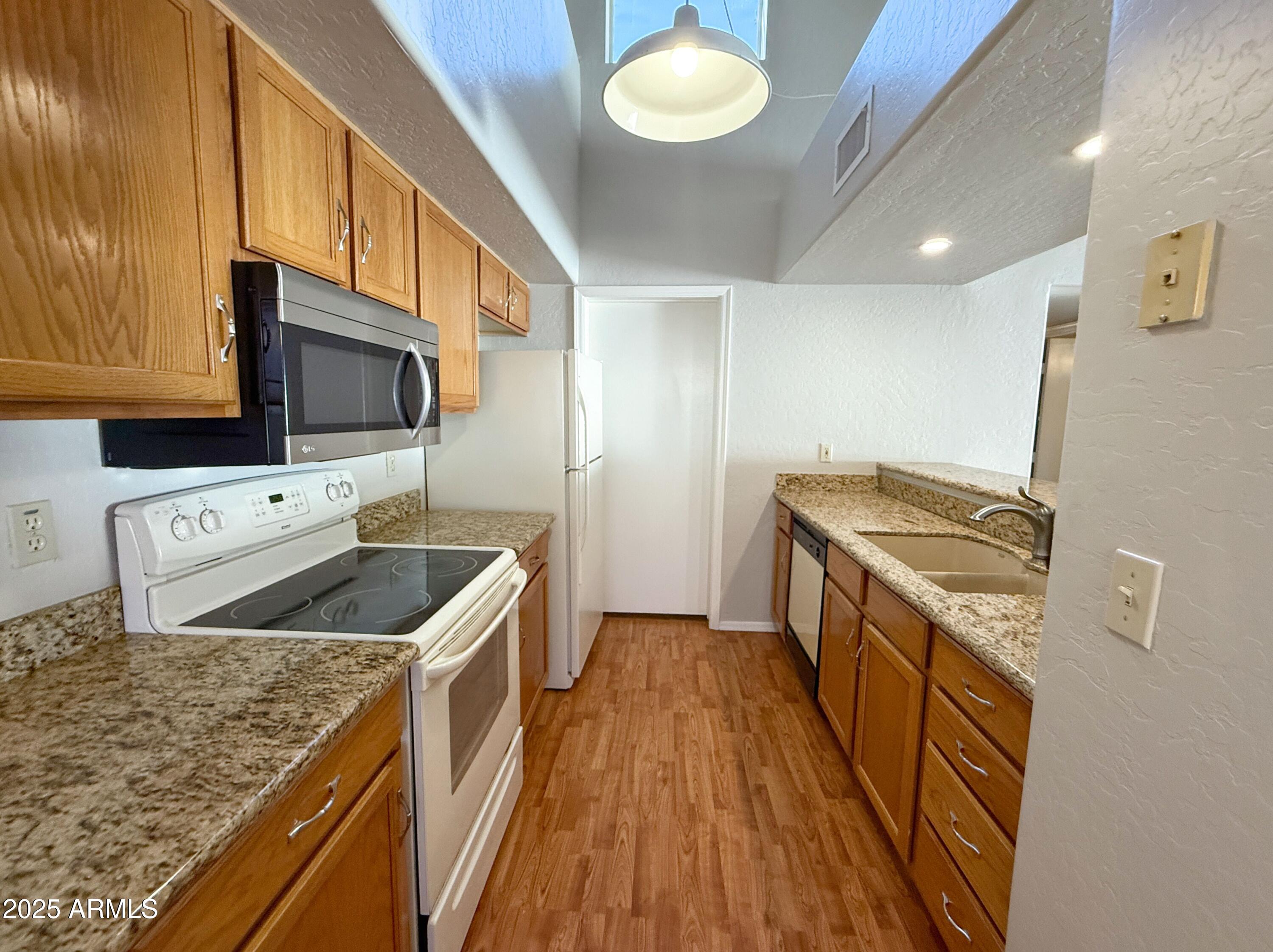 2100 West Lemon Tree Place, Unit 90 Chandler, AZ 85224 - Photo 11 of 24 a kitchen that has a sink and a stove in it