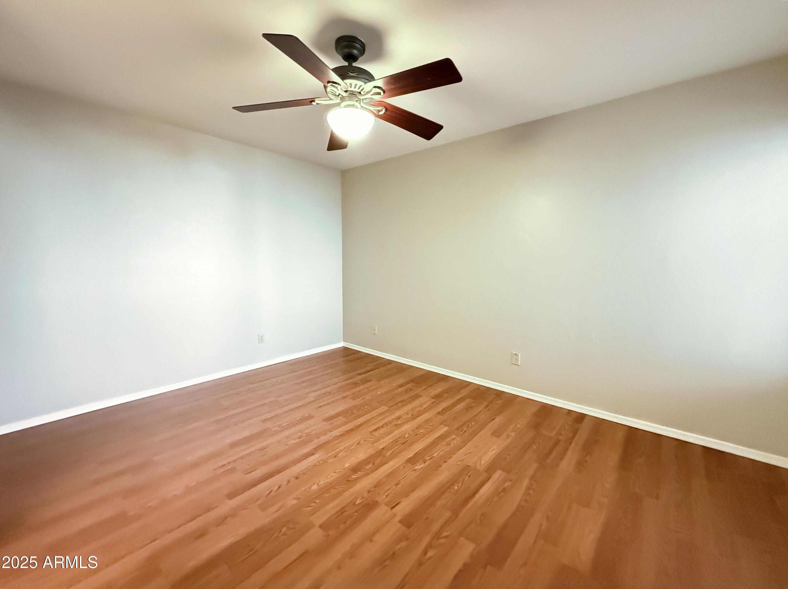2100 West Lemon Tree Place, Unit 90 Chandler, AZ 85224 - Photo 13 of 24 an empty room with wooden floor and a ceiling fan