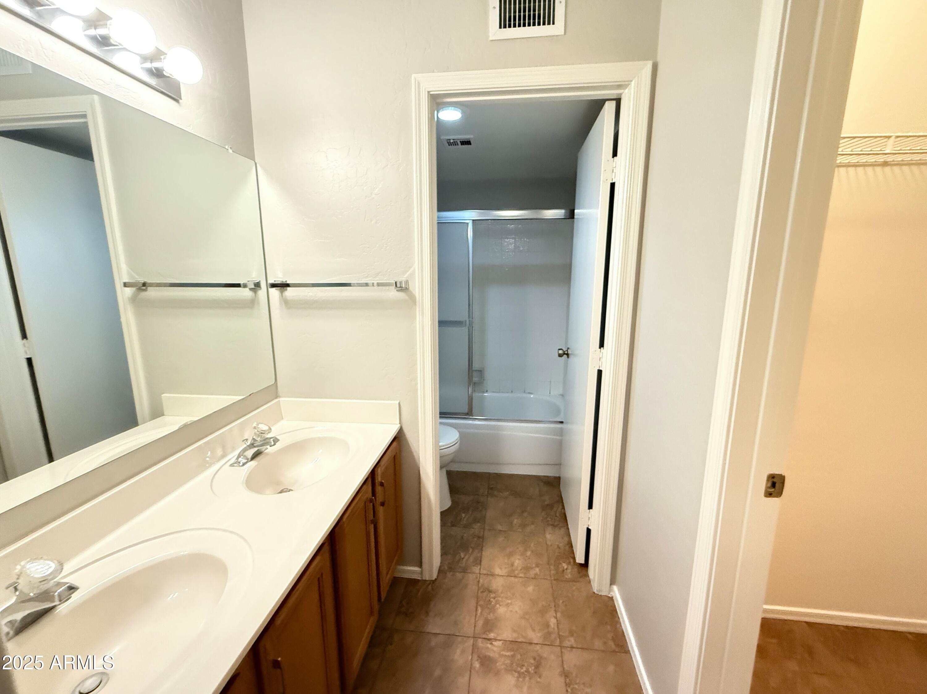 2100 West Lemon Tree Place, Unit 90 Chandler, AZ 85224 - Photo 15 of 24 a bathroom with a tub sink and mirror