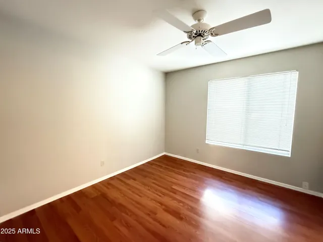 an empty room with a window and a ceiling fan