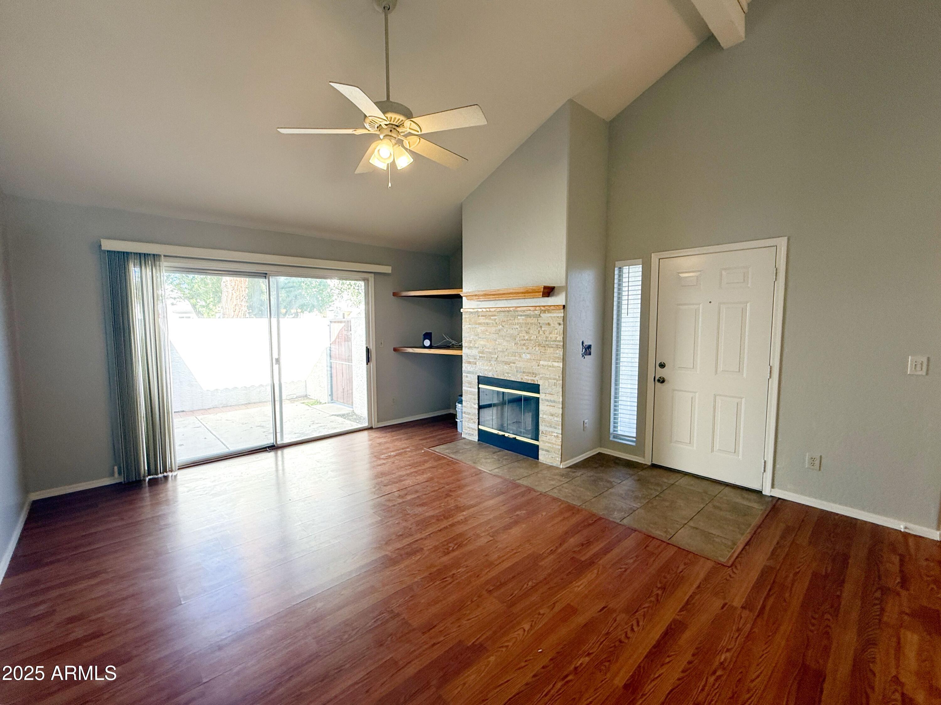 2100 West Lemon Tree Place, Unit 90 Chandler, AZ 85224 - Photo 5 of 24 an empty room with wooden floor fireplace and windows
