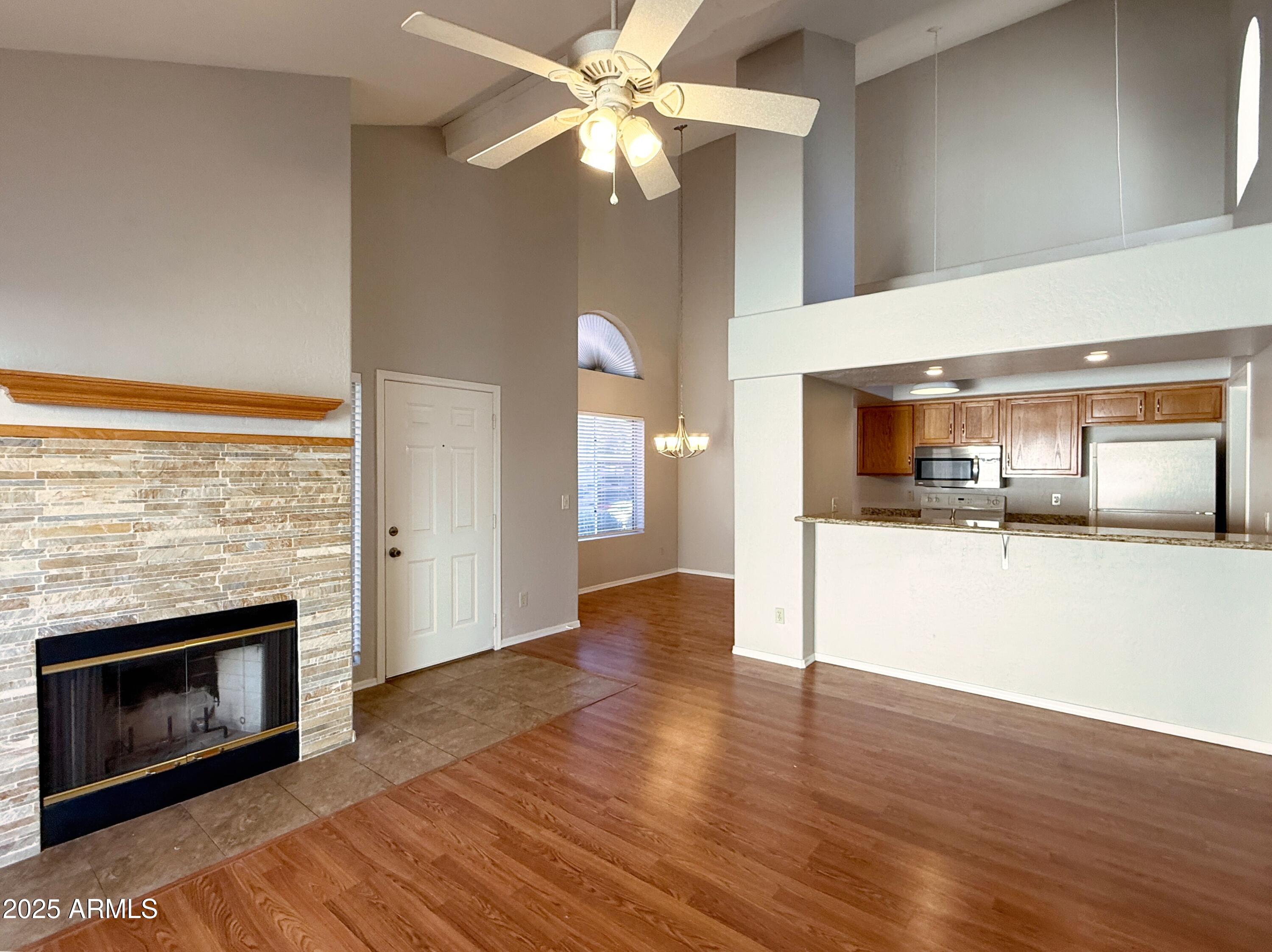 2100 West Lemon Tree Place, Unit 90 Chandler, AZ 85224 - Photo 6 of 24 a view of a kitchen and an empty room with wooden floor