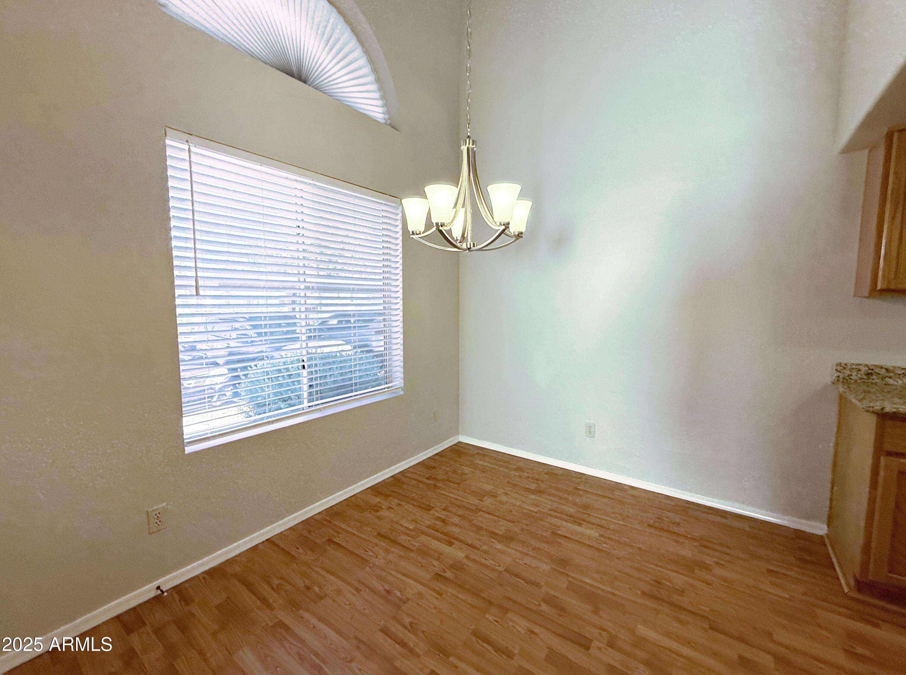 2100 West Lemon Tree Place, Unit 90 Chandler, AZ 85224 - Photo 8 of 24 a view of an empty room with wooden floor and a window