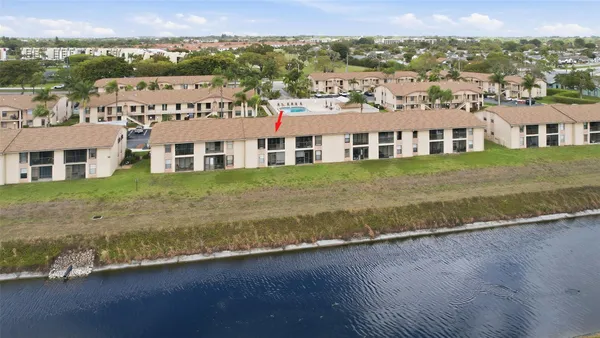 an aerial view of a house with a garden and lake view