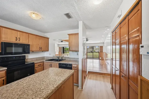a kitchen with stainless steel appliances granite countertop a refrigerator stove top oven and sink