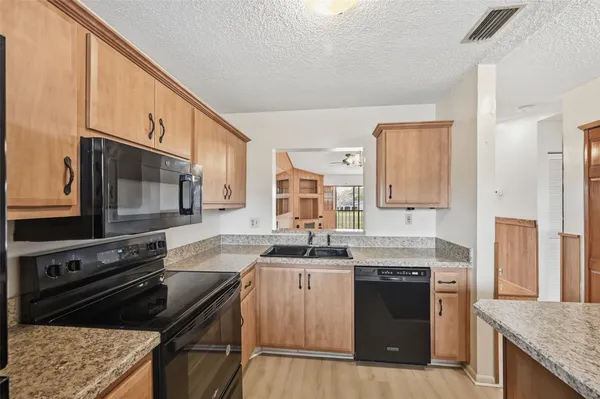 a kitchen with granite countertop a stove sink and cabinets