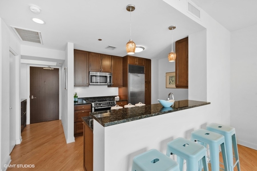 60 East Monroe Street, Unit 2005 Chicago, IL 60603 - Photo 5 of 13 a kitchen with a sink refrigerator and microwave
