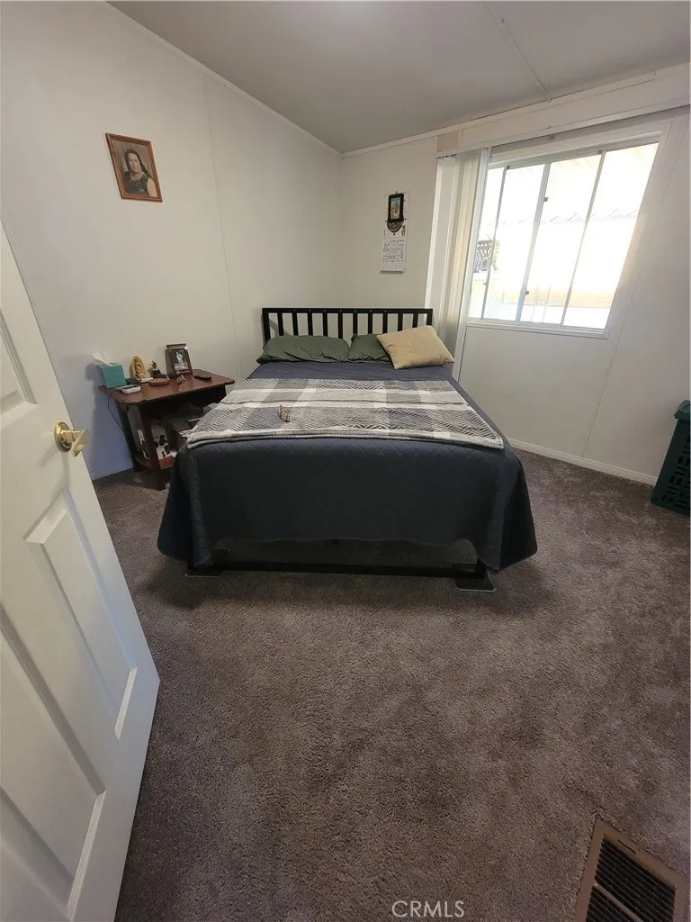 14000 El Evado Road, Unit 43 Victorville, CA 92392 - Photo 14 of 16 a spacious bedroom with a bed and a window