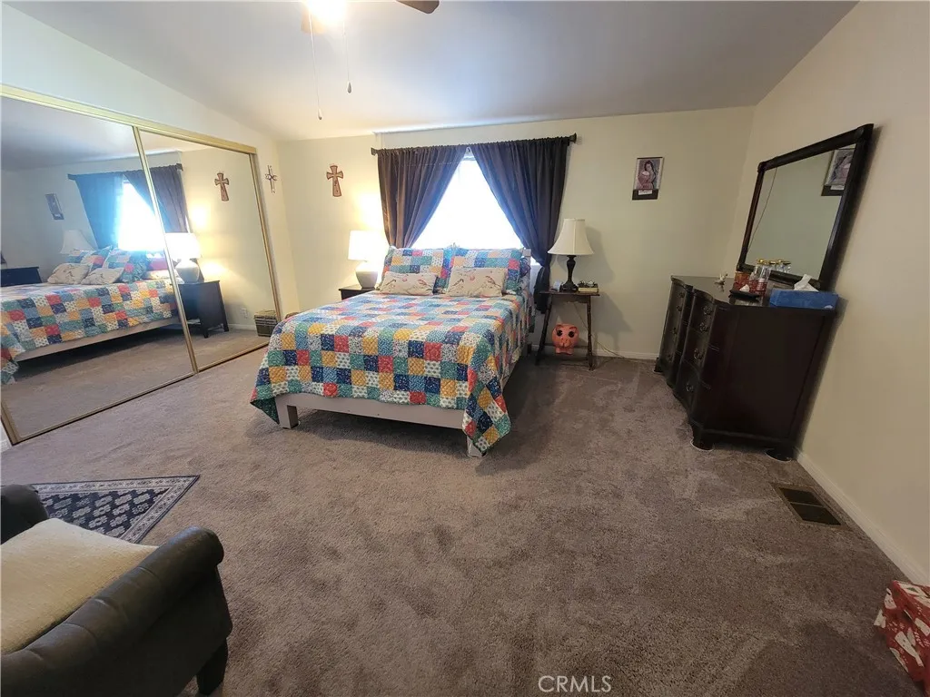 14000 El Evado Road, Unit 43 Victorville, CA 92392 - Photo 15 of 16 a bedroom with a bed and a window