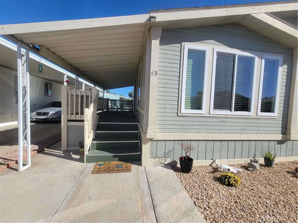 14000 El Evado Road, Unit 43 Victorville, CA 92392 - Photo 2 of 16 a side view of a house with a yard