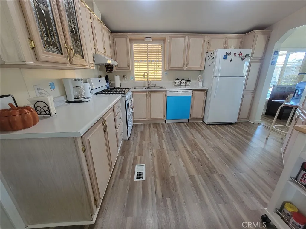 14000 El Evado Road, Unit 43 Victorville, CA 92392 - Photo 10 of 16 a kitchen with white cabinets and white appliances