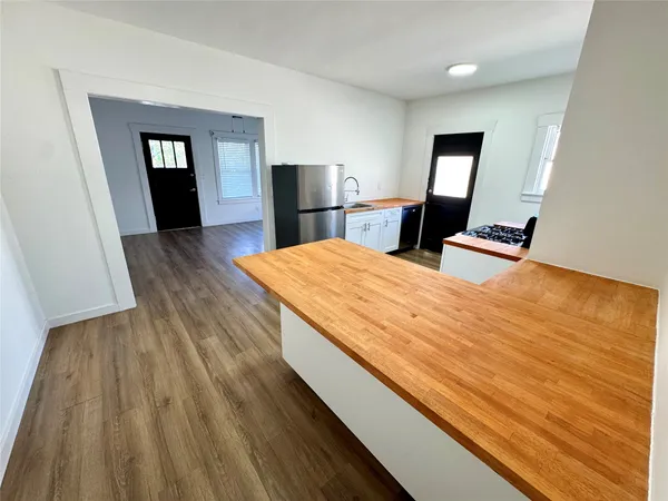 a kitchen with stainless steel appliances granite countertop a refrigerator stove sink and a window