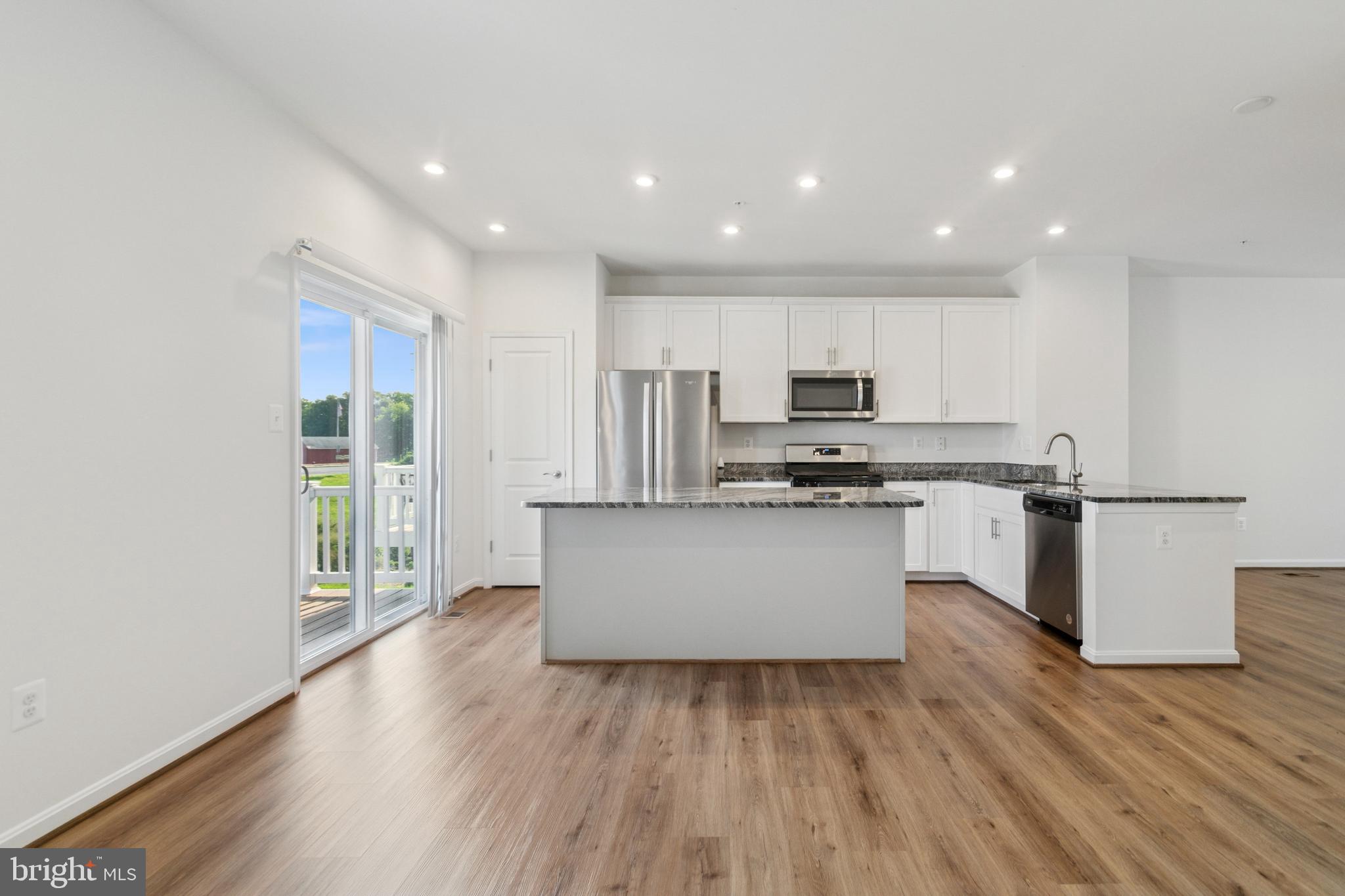 7811 Wolf Run Lane Severn, MD 21144 - Photo 11 of 32 a kitchen with granite countertop white cabinets and stainless steel appliances