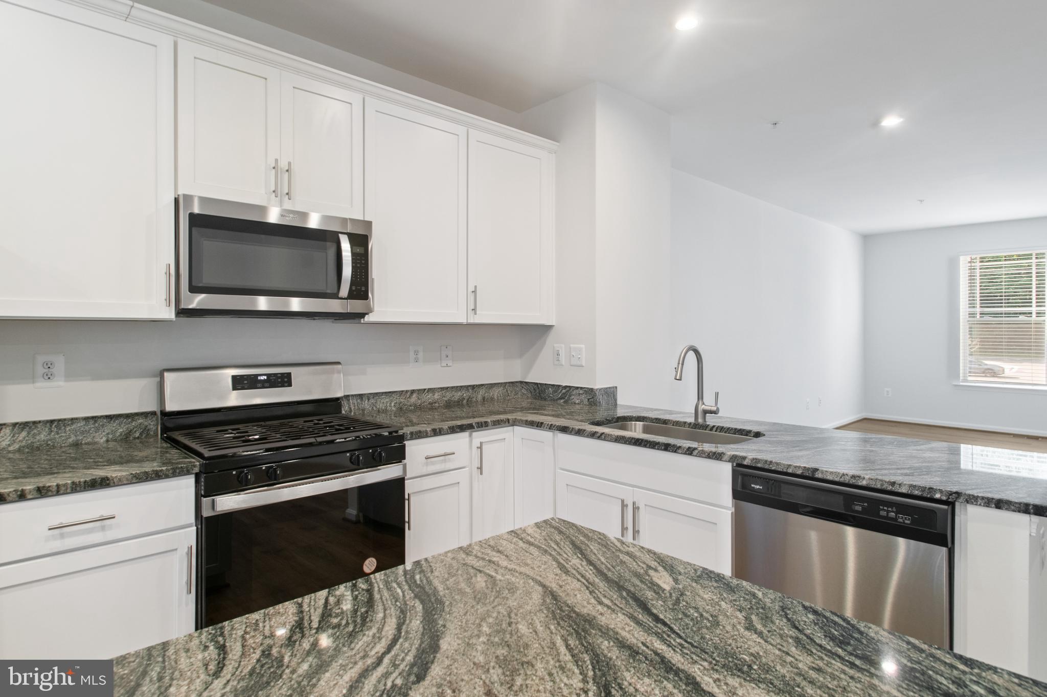 7811 Wolf Run Lane Severn, MD 21144 - Photo 12 of 32 a kitchen with granite countertop a stove and a microwave