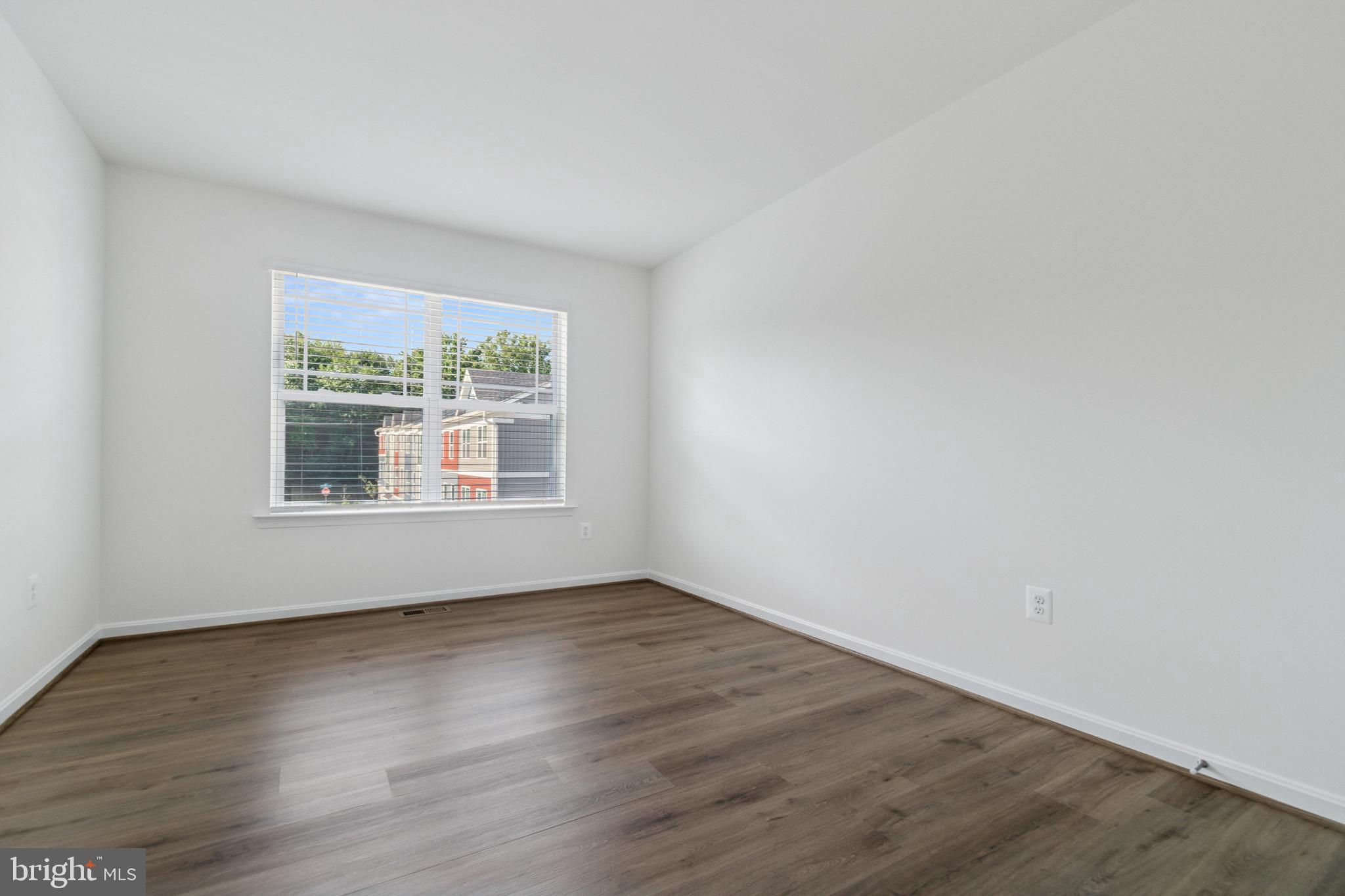 7811 Wolf Run Lane Severn, MD 21144 - Photo 21 of 32 a view of an empty room with wooden floor and a window