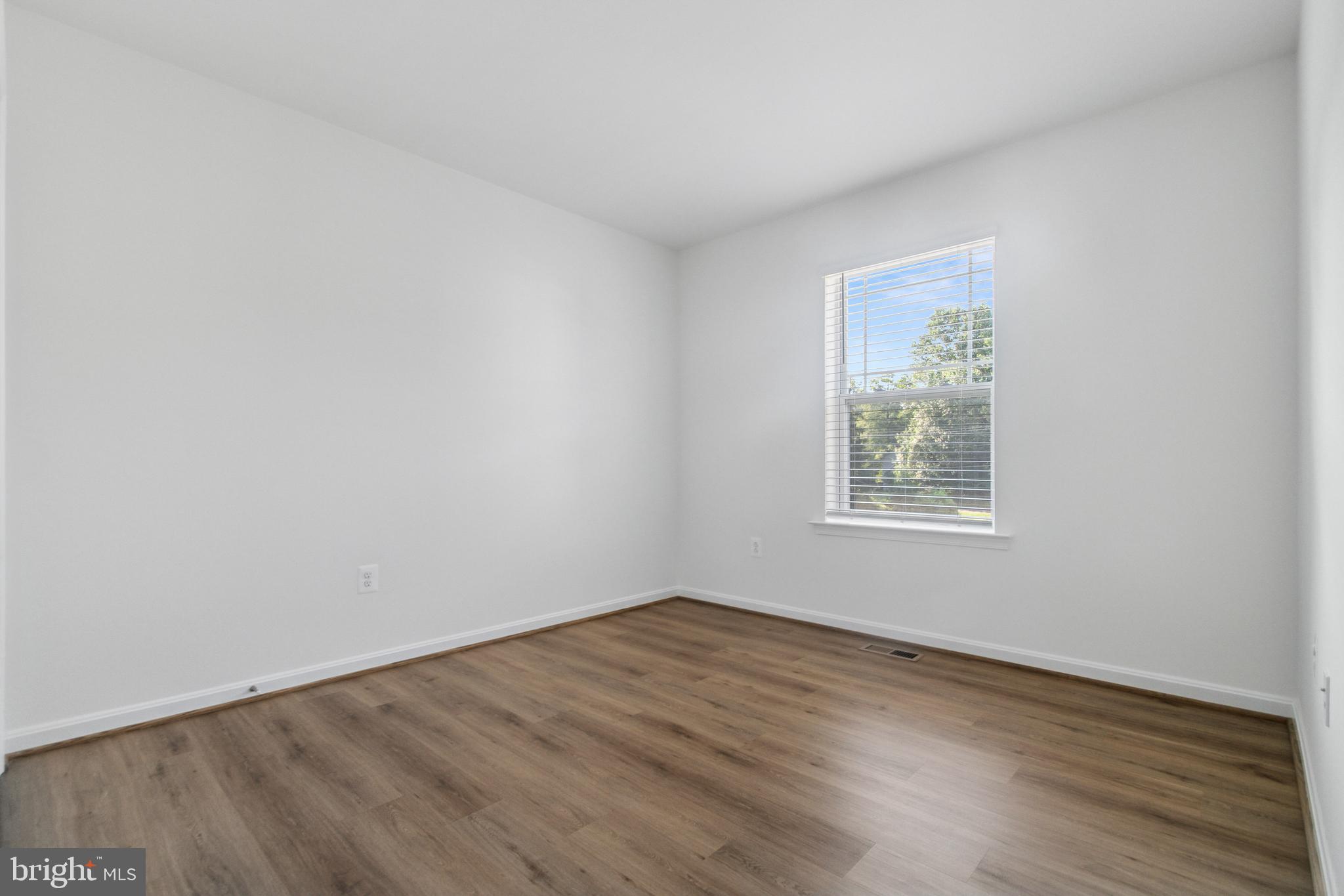 7811 Wolf Run Lane Severn, MD 21144 - Photo 24 of 32 an empty room with wooden floor and windows