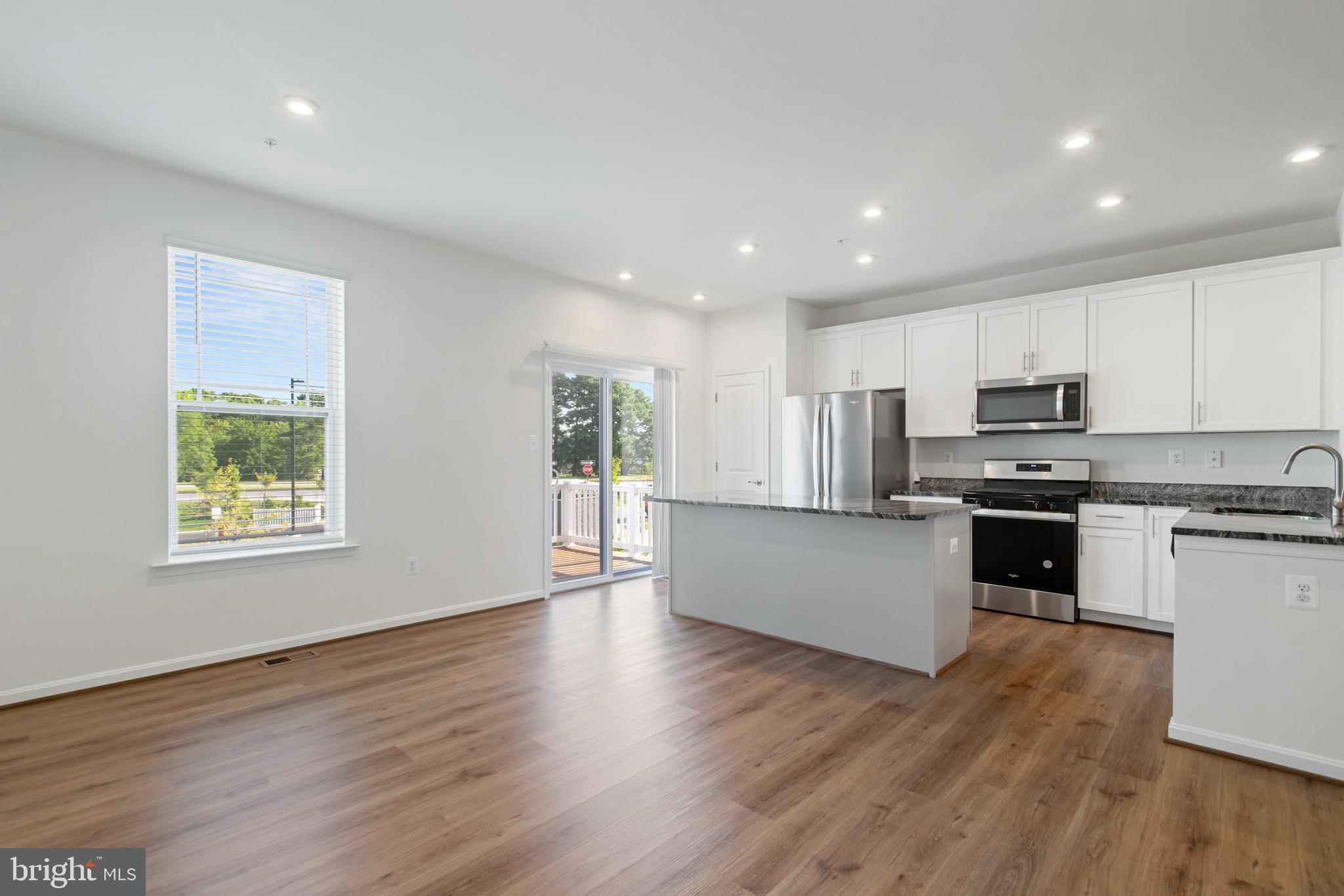 7811 Wolf Run Lane Severn, MD 21144 - Photo 10 of 32 a kitchen with stainless steel appliances granite countertop a stove top oven a sink and white cabinets with wooden floor