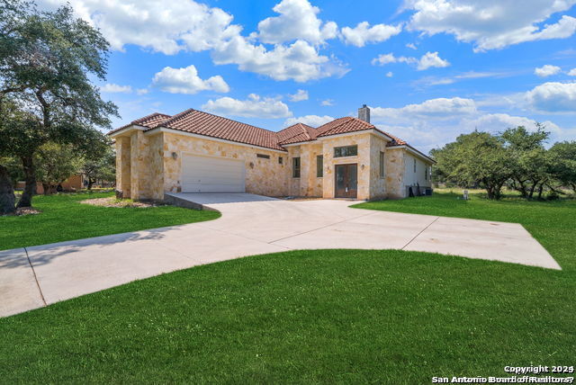 a front view of a house with a garden and yard