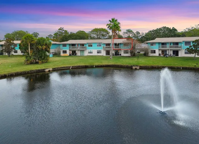 an aerial view of residential houses with outdoor space and lake view