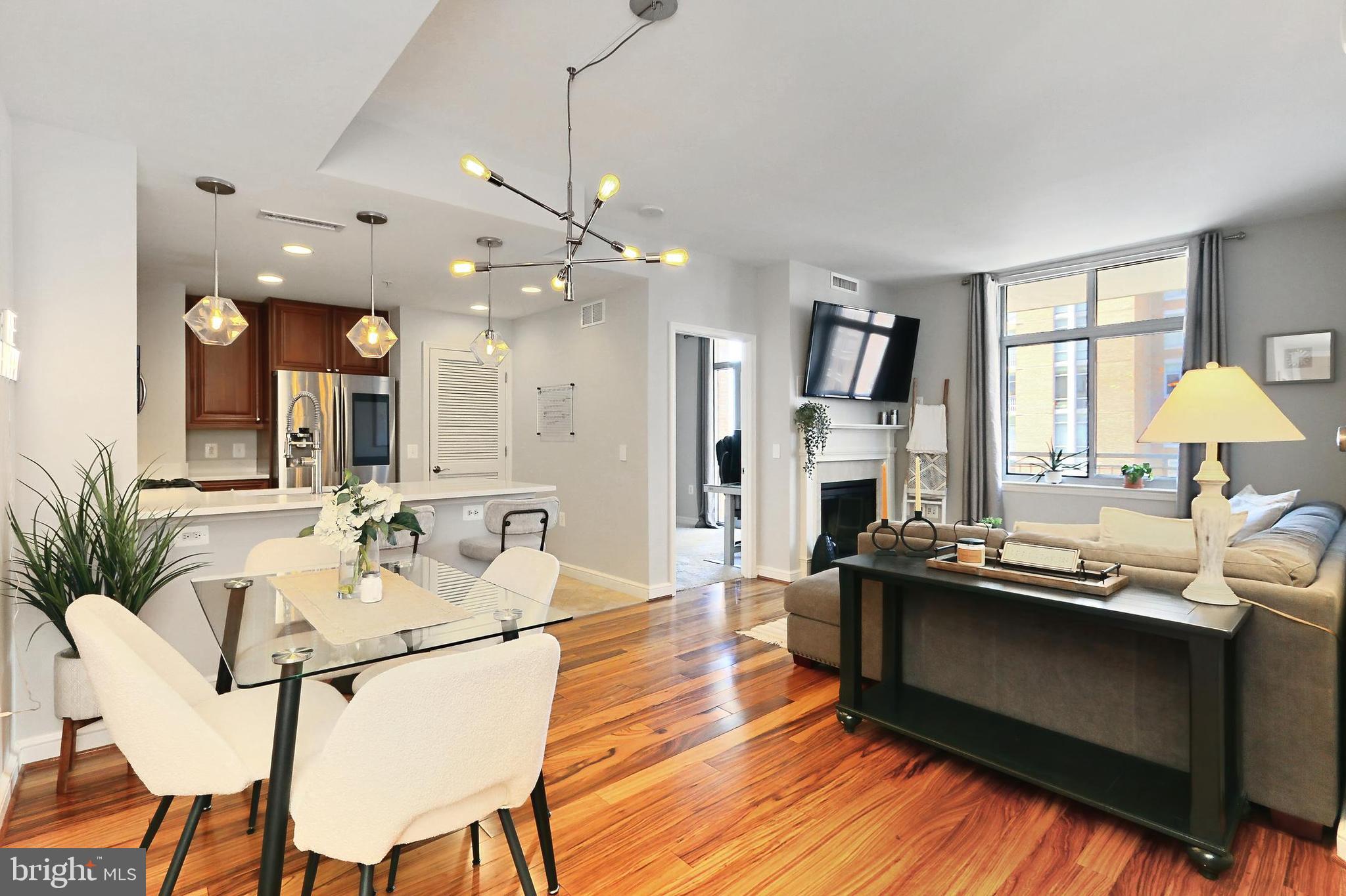 11990 Market Street, Unit 908 Reston, VA 20190 - Photo 1 of 45 a living room with furniture a fireplace and a chandelier