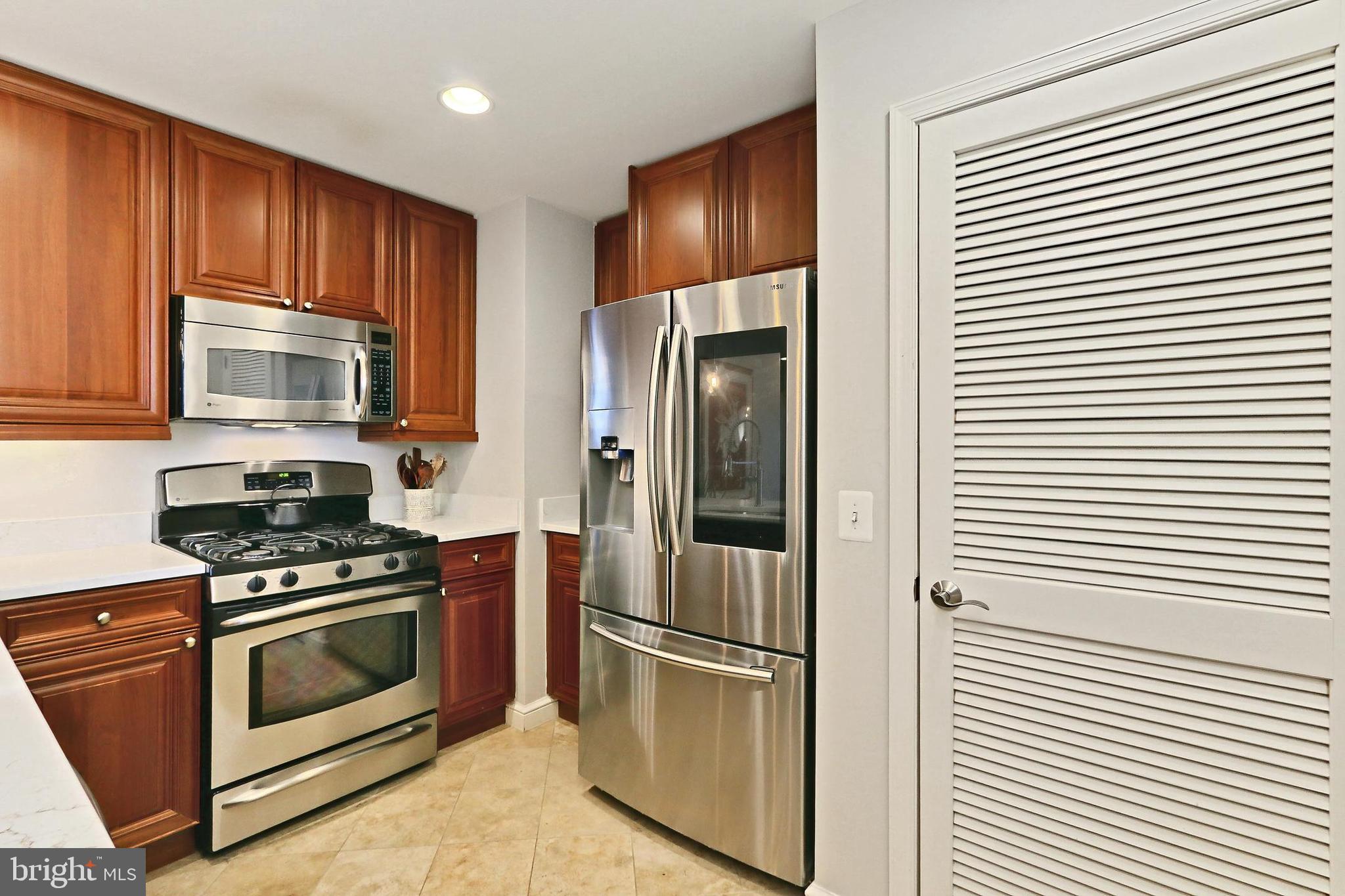 11990 Market Street, Unit 908 Reston, VA 20190 - Photo 7 of 45 a kitchen with stainless steel appliances granite countertop a refrigerator stove and microwave